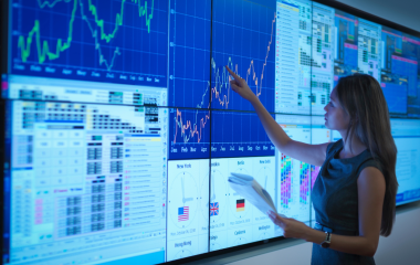 A woman looking at charts on a large screen